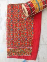 White, blue, yellow phulkari on Red Salwar fabric